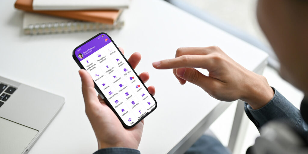 Morador interagindo com o aplicativo eCondos de gestão condominial no smartphone, ilustrando o acesso integrado a informações e serviços do condomínio.